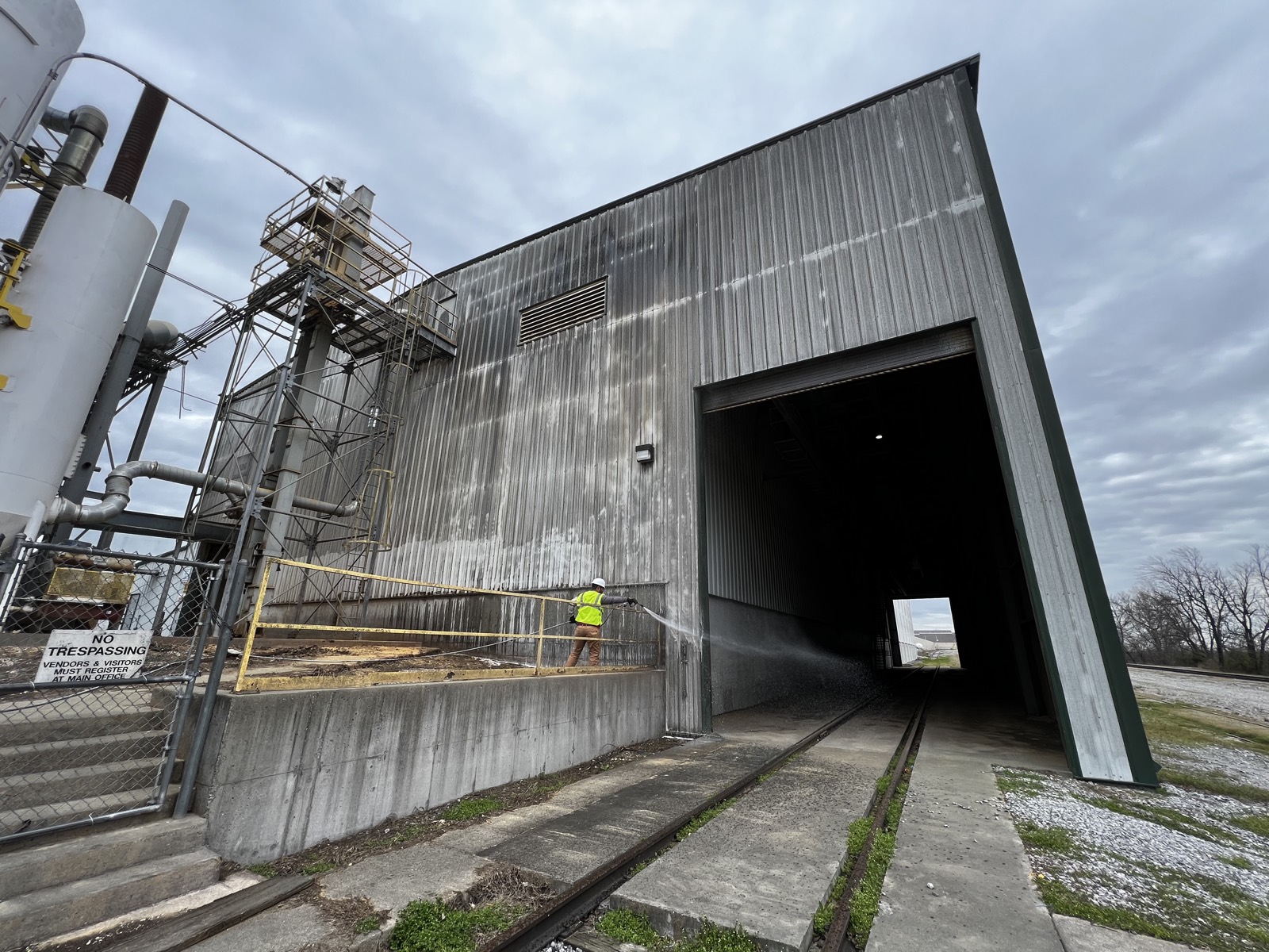Metal industrial building before washing, dark streaked siding