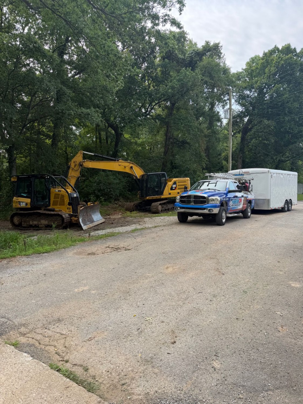 Two Cat machines on a job site next to the Pressures ON truck and trailer