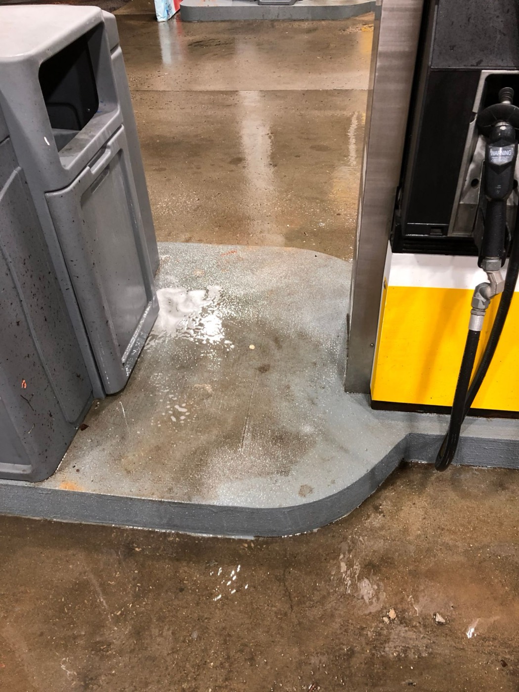 Gas station pump island stained with oil before cleaning