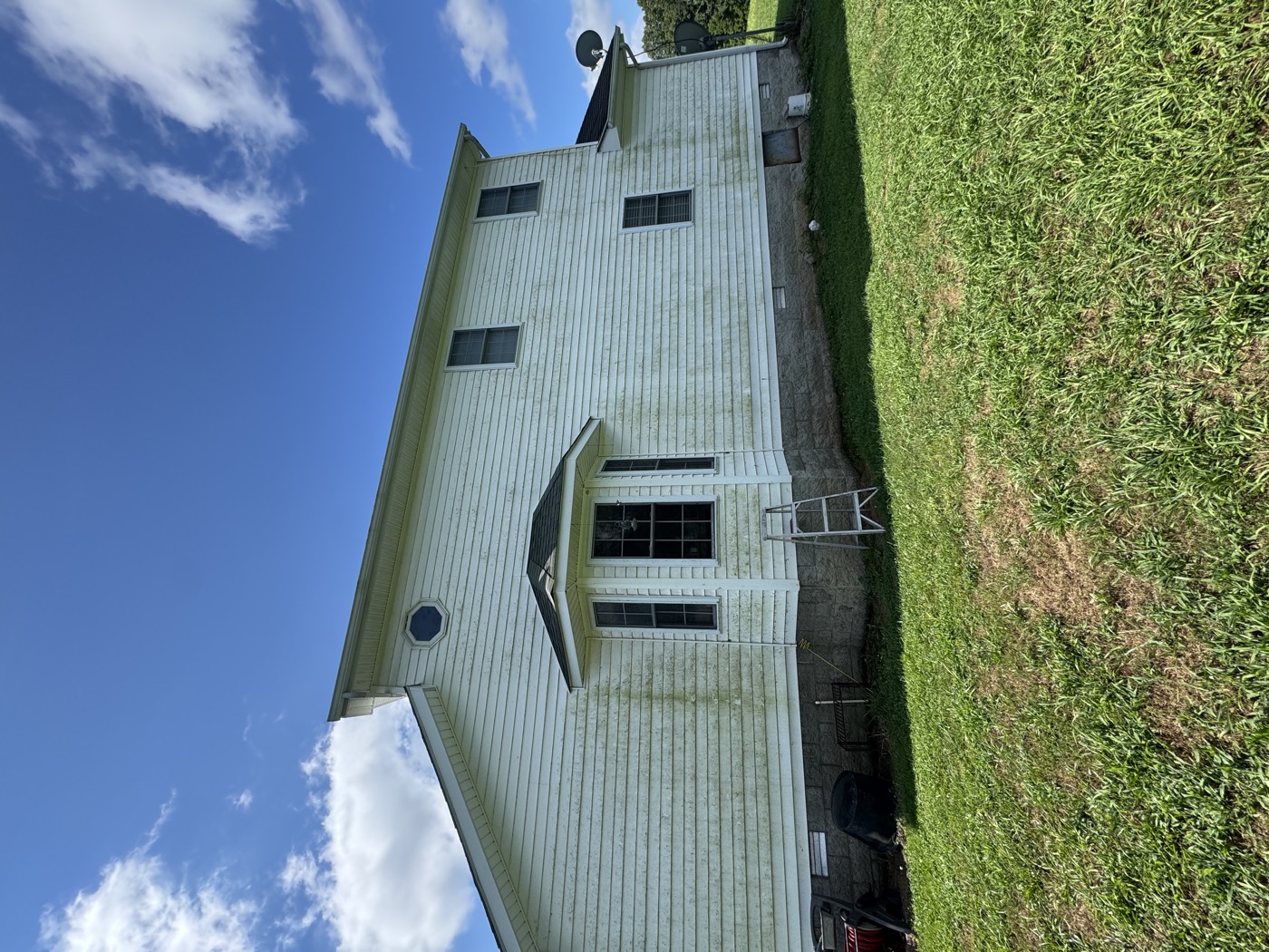 Back of a white house with mildew before washing