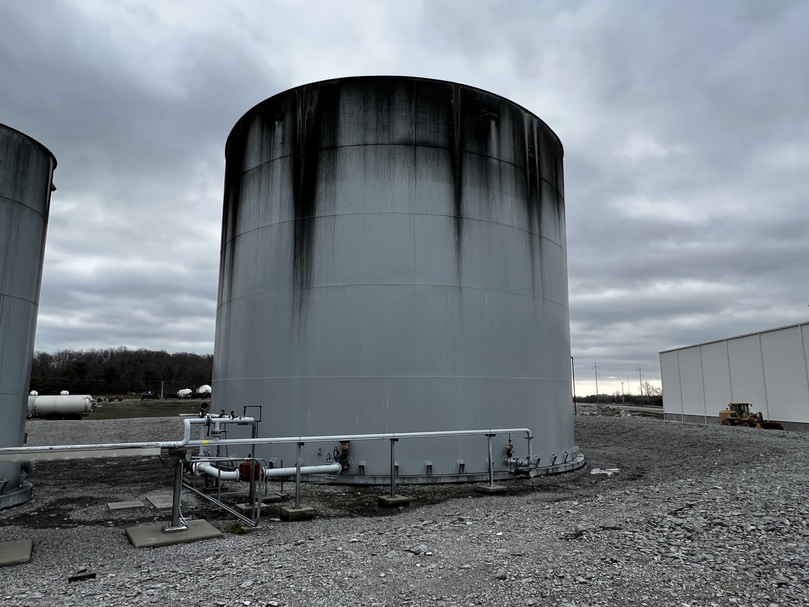 Large storage tank with black runoff stains before washing